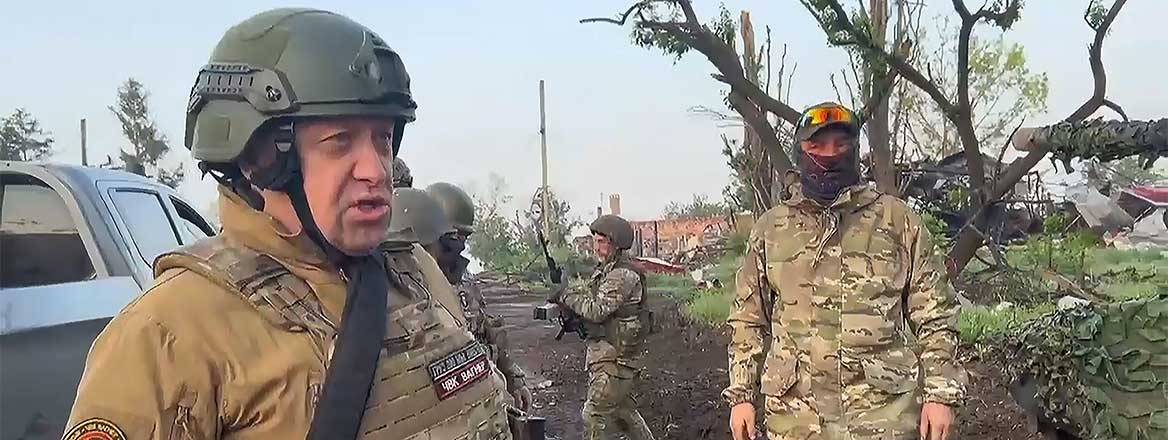 Yevgeny Prigozhin standing in uniform near his soldiers